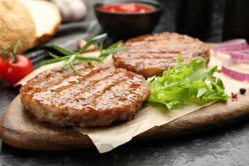 Delicious hamburger patties and spices on black table, closeup