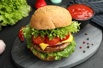 Delicious hamburger with patty served on black table, closeup