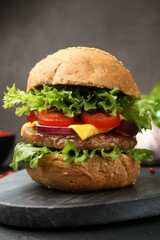 Delicious hamburger with patty served on black table, closeup