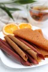 Tasty fruit leather rolls on white table, closeup