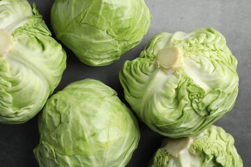 Obraz premium Fresh green cabbages on grey table, flat lay