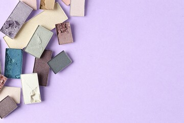 Beautiful eyeshadow refill pans on lilac background, flat lay. Space for text