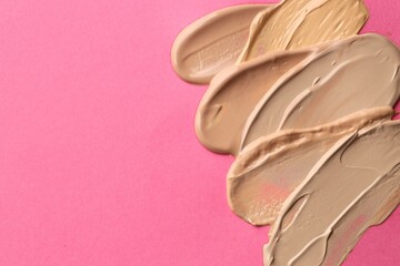 Colorful skin foundations on magenta background, flat lay. Space for text