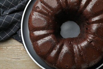 Tasty chocolate bundt cake on wooden table, top view