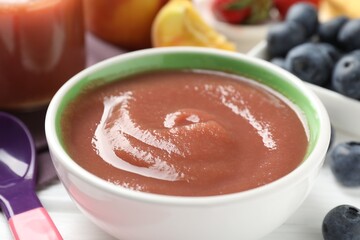 Baby food. Tasty puree in bowl, spoon and ingredients on white table, closeup