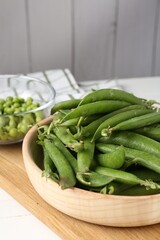 Fresh ripe green peas on white wooden table, closeup