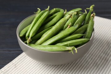 Fresh ripe green peas on black wooden table, closeup