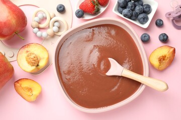 Baby food. Tasty puree in bowl, spoon, teether and ingredients on pink table, flat lay