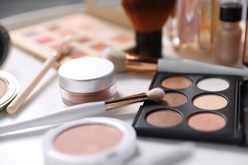 Different makeup products on white table, closeup