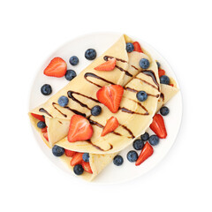Tasty crepes with strawberries, blueberries and chocolate sauce isolated on white, top view
