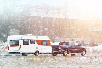 Camper trailer journey through snowy countryside © AlexGo