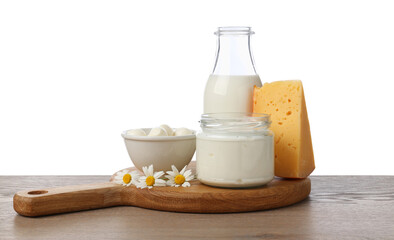 Different fresh dairy products and chamomile flowers on wooden table against white background