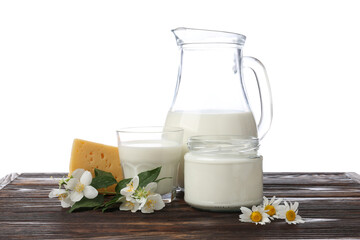 Different fresh dairy products and flowers on wooden table against white background