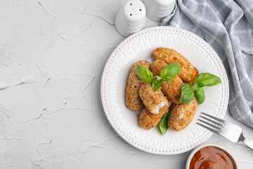 Tasty fried croquettes, basil and sauce on white textured table, flat lay. Space for text