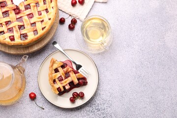 Tasty cherry pie, berries and tea on grey textured table, flat lay. Space for text