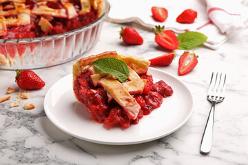 Piece of tasty strawberry pie and berries on white marble table, closeup