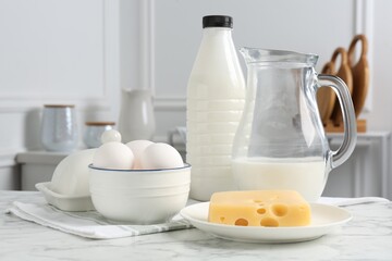 Different dairy products and eggs on white marble table indoors