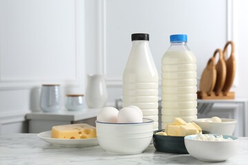 Different dairy products and eggs on white marble table indoors. Space for text