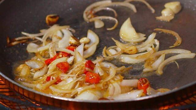 Frying garlic, peppers and onions in a pan