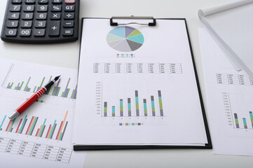 Financial background, clipboard with financial data, colorful pie and bar charts, calculator on the...