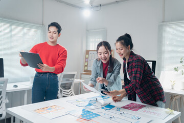 Young asian ui/ux web designers working together developing a mobile application prototype for...