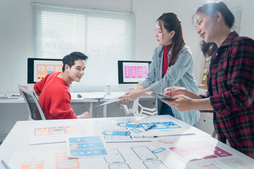 Young Asian ux designers working together in the office discussing the design of a new mobile app...