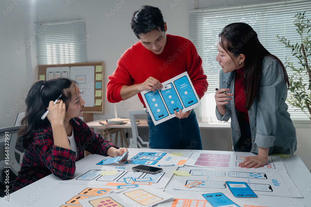 Poster creative team in a modern office collaborating on mobile app design. they are discussing layout and 
