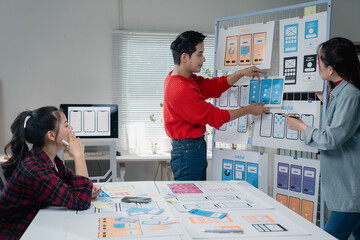 Creative team engaged in developing a mobile app interface, discussing design elements and user...