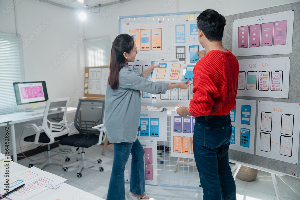 Poster two ux/ui designers are analyzing and discussing the design of a new mobile application interface, w