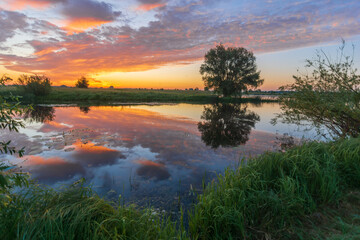 awesome summer sunrise over the lake and fields