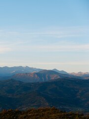 breathtaking view showcases rolling mountains and peaks under a clear sky during sunset in Pyreneyes