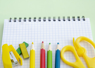 The Back to school concept with school supplies on a green background, free space for copying in a...