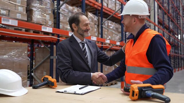 Businessman and warehouse worker shaking hands in a logistics center, celebrating a successful agreement