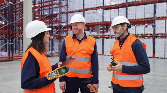 Warehouse team members collaborating using handheld devices, managing logistics efficiently within spacious, organized storage facility