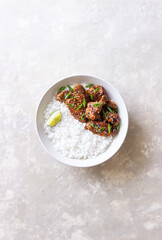 Chicken wings in teriyaki sauce with rice, sesame and onion. Asian food.