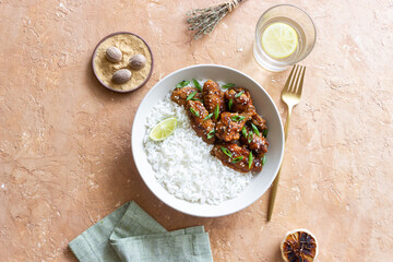 Chicken wings in teriyaki sauce with rice, sesame and onion. Asian food.