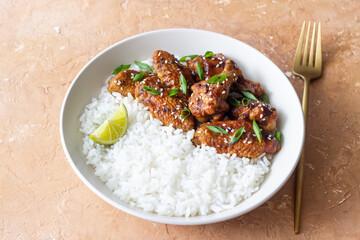 Chicken wings in teriyaki sauce with rice, sesame and onion. Asian food.