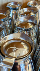 Silver pitchers gleam like lunar sentinels, embodying caffeinated musings for International Coffee Day and reflective coffee breaks
