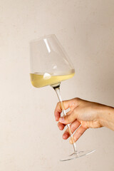 A delicate hand twirls a crystal goblet of golden wine, evoking Bacchanalia's revelry and the...
