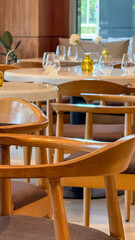 Sun-dappled Scandinavian chairs embrace serene, intimate dining setting, perfect for Hygge gatherings or National Relaxation Day celebrations