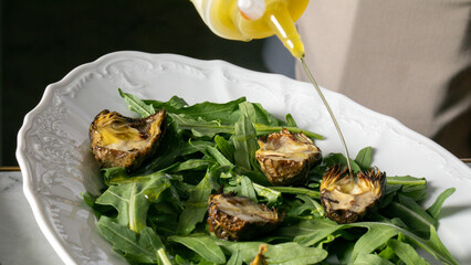Golden drizzle over charred artichokes and fresh arugula evokes Mediterranean nostalgia, aligning...