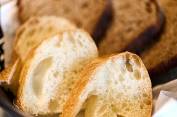 Slices of crusty bread arranged in a basket, inviting diners to enjoy their meal together at noon.