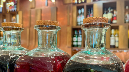 Corked elixirs glisten in amber glow, echoing medieval alchemy and mysterious Samhain potions, inviting curious exploration