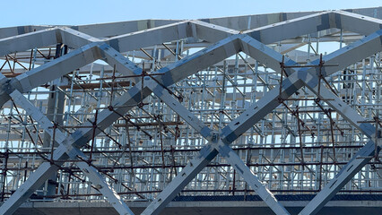 Intricate lattice of iron beams echoes urban metamorphosis, capturing International Workers' Day...