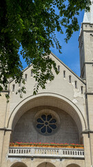Sunlit Gothic arch whispers history, enchanting All Saints' Day, architectural serenity, vibrant geraniums in eternal bloom