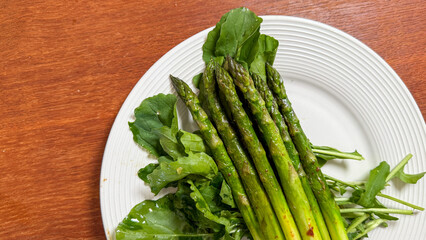 Grassy spears of asparagus entwine with peppery arugula, evoking springtime renewal and Earth Day's verdant celebrations