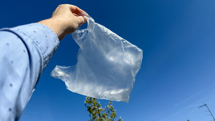 Elevated against a cerulean sky, a translucent plastic bag dances whimsically, reminiscent of...