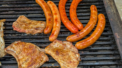 Juicy sausages and sizzling pork steaks dance on a grill, evoking Oktoberfest warmth and backyard...