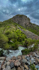Majestic verdant hill under tempestuous skies, echoing whispers of Earth Day reverence and...