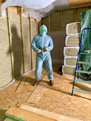 In a temple of timber, a masked builder enacts a dance of insulation wizardry, embodying Earth Day's mindful crafts